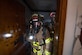 U.S. Air Force fire protection specialists, assigned within the U.S. Central Command area of responsibility, prepare to enter a simulated burning building during a National Fire Protection Association 1410 drill at an undisclosed location, April 23, 2024. The NFPA 1410 drills consisted of firefighters responding to a simulated structural fire, giving firefighting crews an objective method of measuring performance for initial fire suppression and rescue procedures, ensuring they are ready to respond efficiently and effectively to real-world emergencies. (U.S. Air Force Photo)