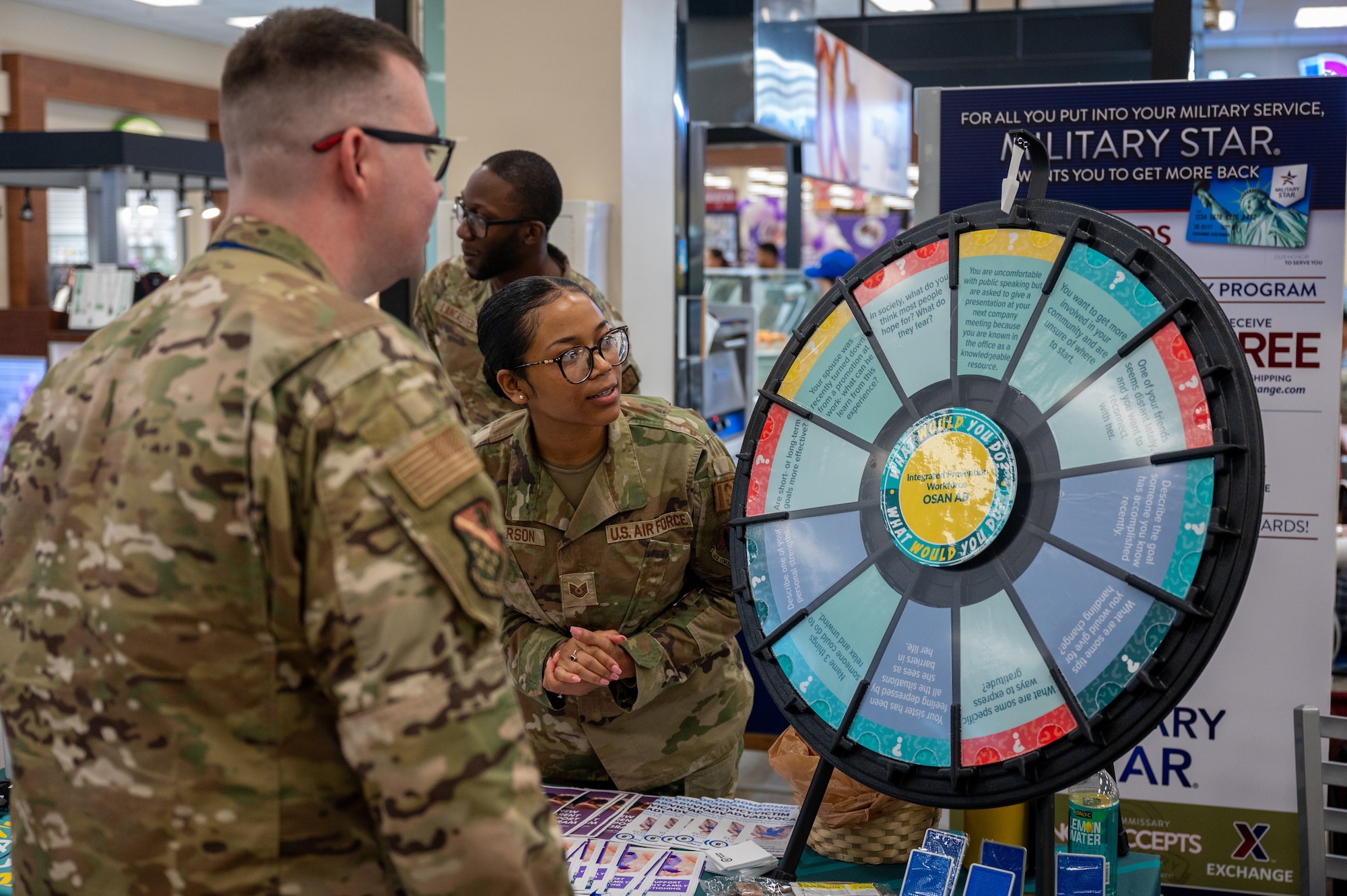 U.S. Air Force Staff Sgt. Brandon Hawkinson, 694th Intelligence, Surveillance, and Reconnaissance Group, all source non-commissioned officer in charge, left, and Tech. Sgt. Amaree Anderson, 303rd Intelligence Squadron resource advisor, discuss a question during a Sexual Assault Awareness and Prevention Month outreach event at Osan Air Base, Republic of Korea, April 22, 2024. The 51st FW Sexual Assault Prevention and Response office has policies and programs that are designed to empower Airmen to foster a culture of dignity, mutual respect and trust. (U.S. Air Force photo by Airman 1st Class Chase Verzaal)