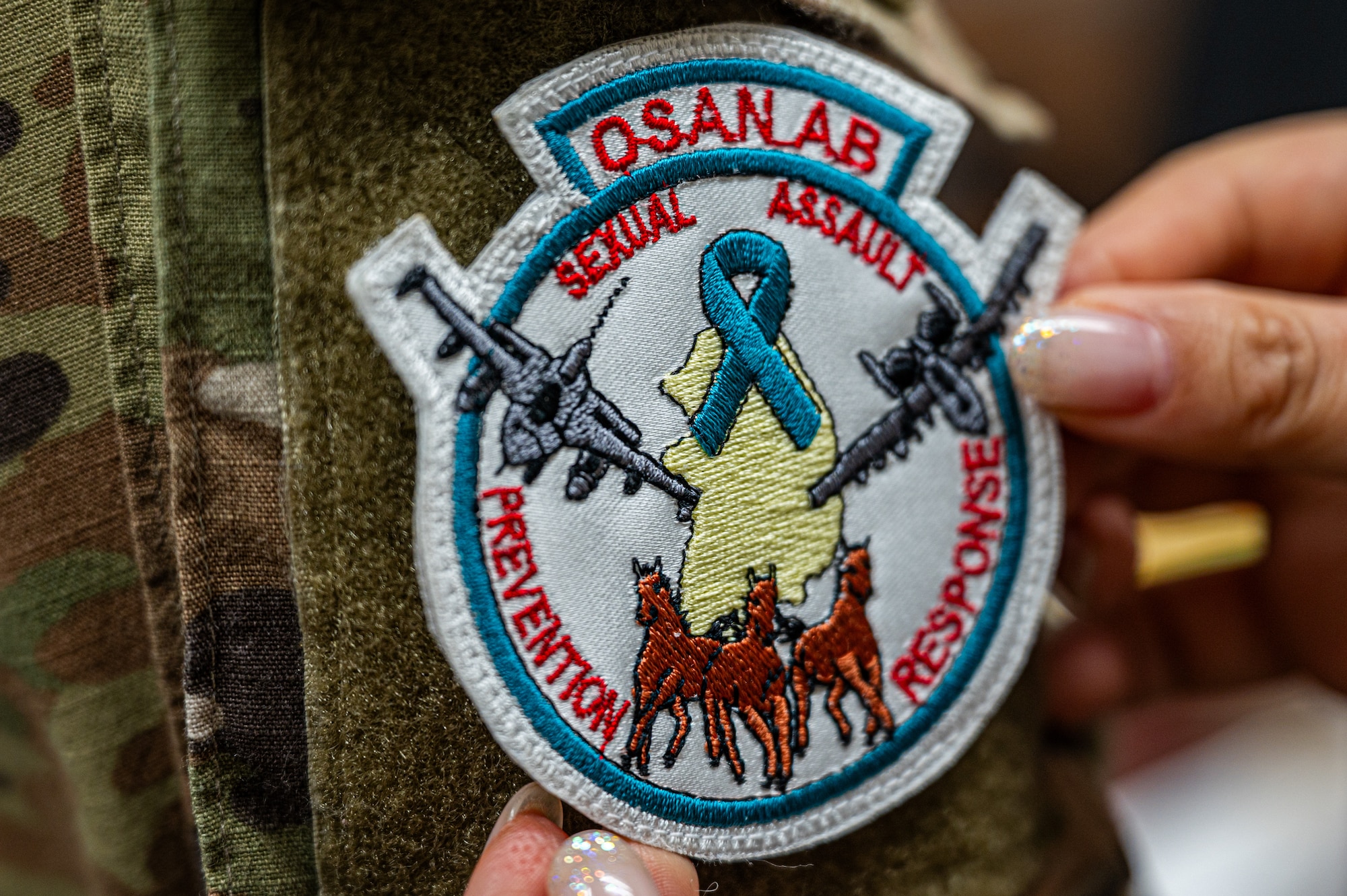 U.S. Air Force Capt. Favian Chung, 51st Fighter Wing director of protocol, receives a wing approved Osan Air Base Sexual Assault, Prevention and Response patch during Sexual Assault Awareness and Prevention Month at Osan AB, Republic of Korea, April 25, 2024. The 51st FW supports SAAPM by facilitating conversation and hosting events to raise awareness, including intervention and response training and reflection events like “What Were You Wearing?”. (U.S. Air Force photo by Airman 1st Class Chase Verzaal)