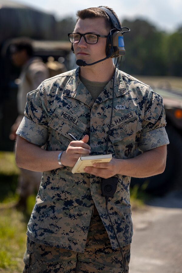 U.S. Marine Corps Sgt. Jarod Merrill, an air delivery specialist with 2nd Distribution Support Battalion, Combat Logistics Regiment 2, 2nd Marine Logistics Group, communicates with pilots over a radio during an air delivery training in Surf City, North Carolina, April 26, 2024. 2nd DSB conducted the training to evaluate their Marines' combat effectiveness and enhance air delivery skills in a controlled environment to better prepare the unit for future operations. (U.S. Marine Corps photo by Lance Cpl. Jessica J. Mazzamuto)