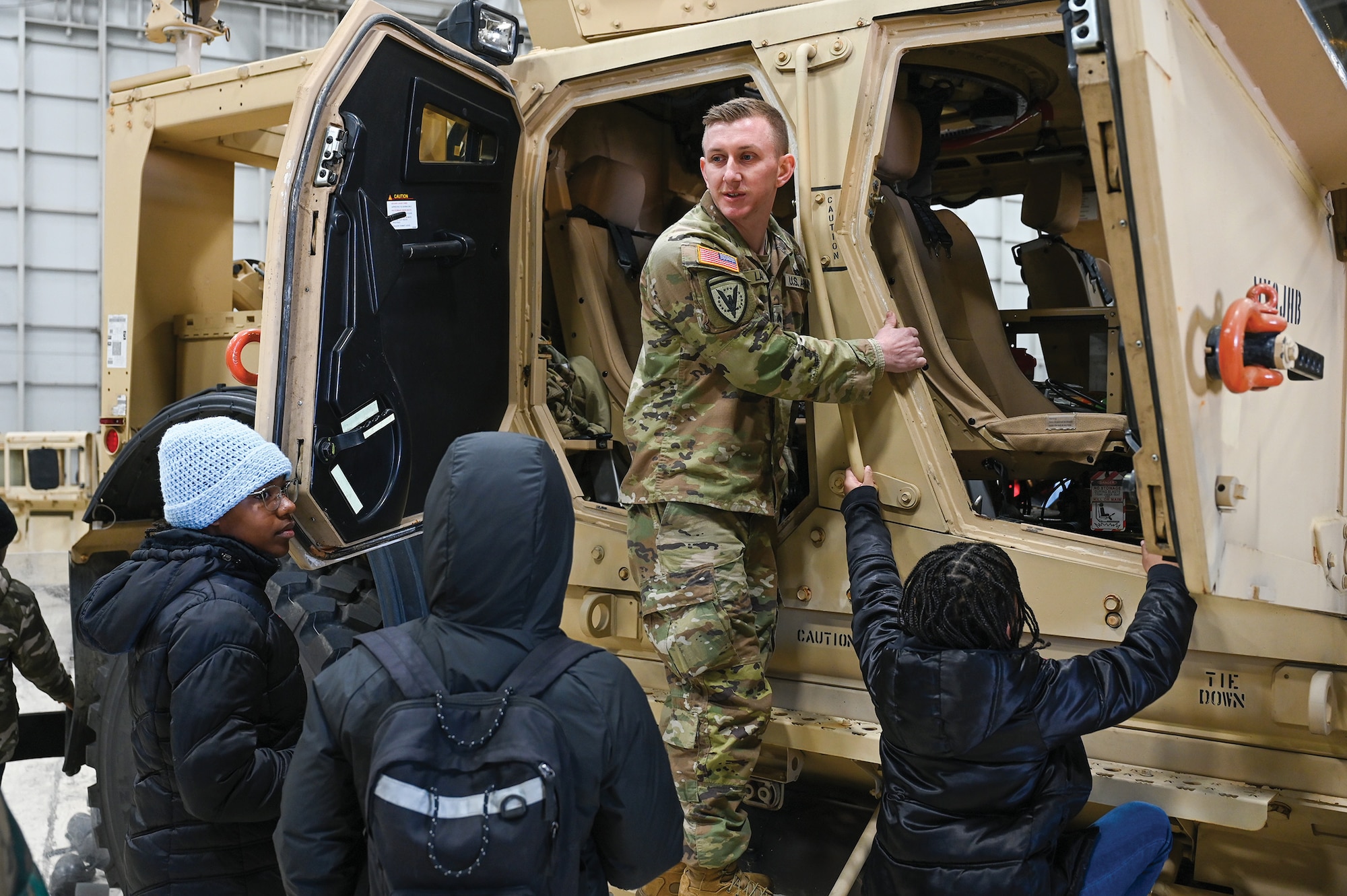 U.S. Army Staff Sgt. Kyle Lane, 324th Military Police Company, Armory, in Middletown, Ohio, explains the features of a Mine Resistant Ambush Protected All-Terrain Vehicle to young members of Cincinnati-based nonprofit organization Black Boys in Tech at Wright-Patterson Air Force Base, Ohio, April 6, 2024. (U.S. Air Force photo/Master Sgt. Patrick O’Reilly)