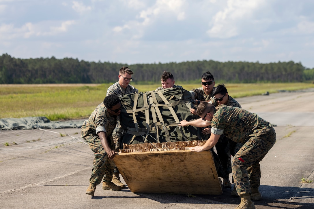 U.S. Marine Corps air delivery specialists with 2nd Distribution Support Battalion, Combat Logistics Regiment 2, 2nd Marine Logistics Group, recover cargo during an air delivery training in Surf City, North Carolina, April 26, 2024. 2nd DSB conducted the training to evaluate their Marines' combat effectiveness and enhance air delivery skills in a controlled environment to better prepare the unit for future operations. (U.S. Marine Corps photo by Lance Cpl. Jessica J. Mazzamuto)