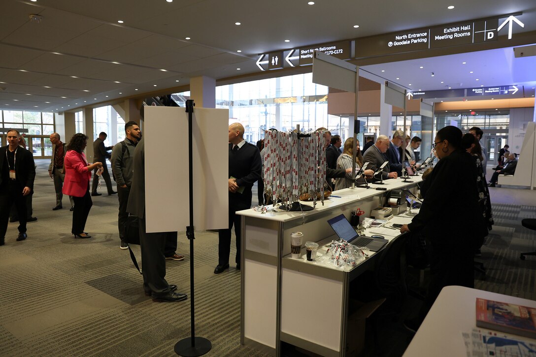 Many people wait in line to check in in a conference center.
