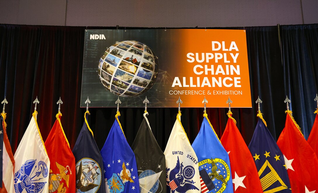 A sign sits above a group of flags.