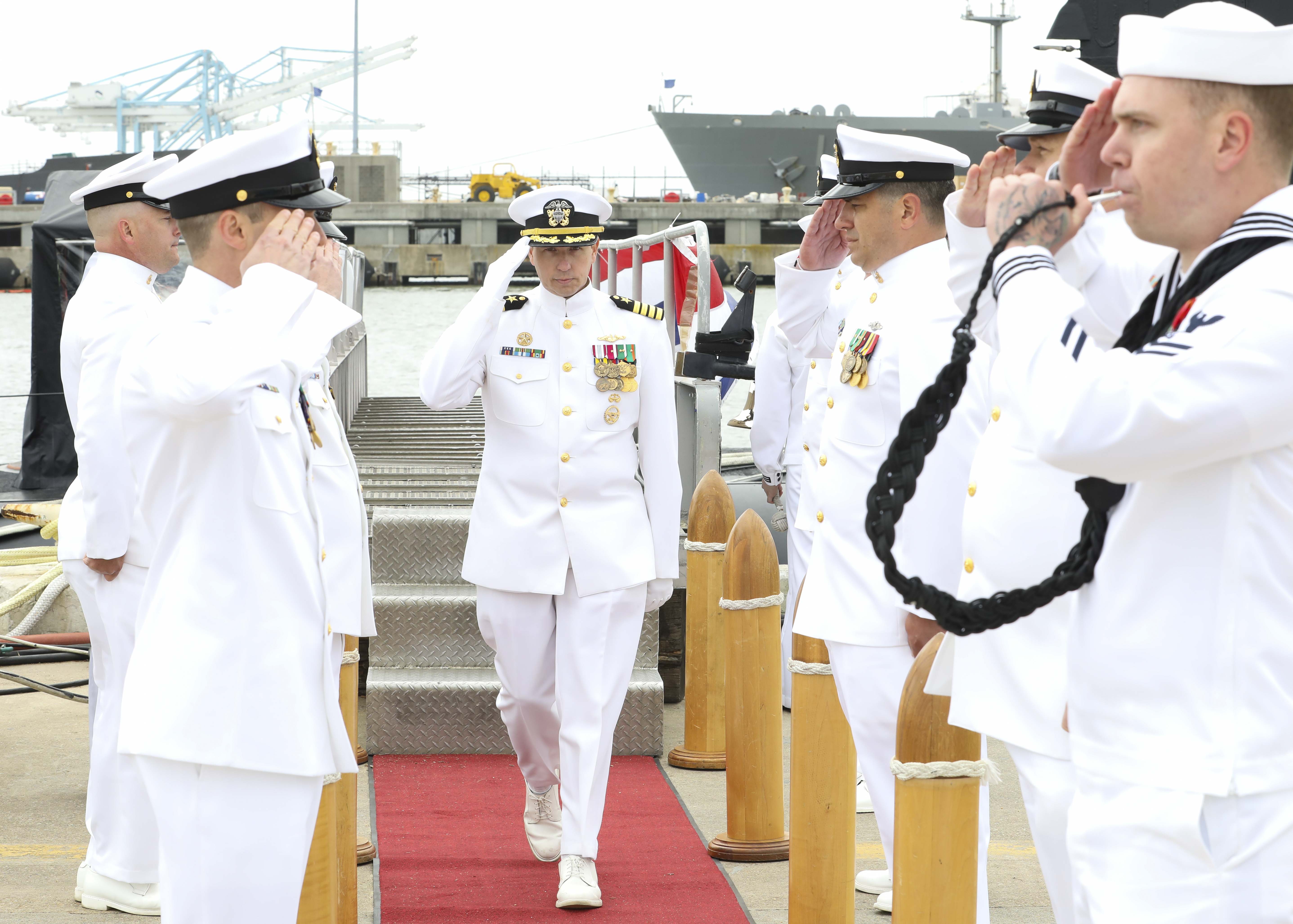 Capt. David Fassel, commodore, Submarine Squadron (CSS) SIX, renders a salute to sideboys during the Commander, Submarine Squadron (CSS) SIX change of command ceremony, April 25.