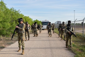 U.S. Air Force students in Expeditionary Readiness Training Course 24-7 patrol at the start of a simulated field operation, Goodfellow Air Force Base, Texas, April 12, 2024. Students were given an objective to execute during the field operation and were required to apply the knowledge gained throughout the course to complete the mission. (U.S. Marine Corps photo by Cpl. Jessica Roeder)