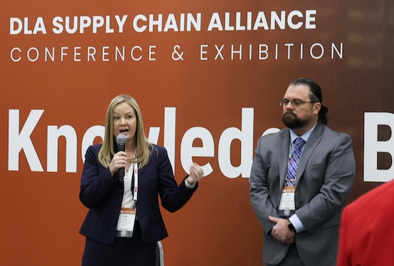 A man and woman speak at the knowledge bar in the exhibition hall.