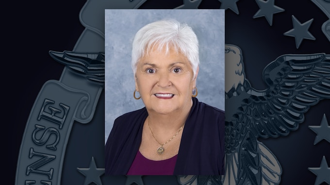 A portrait of Darlene Ferrante with a background featuring the DLA emblem