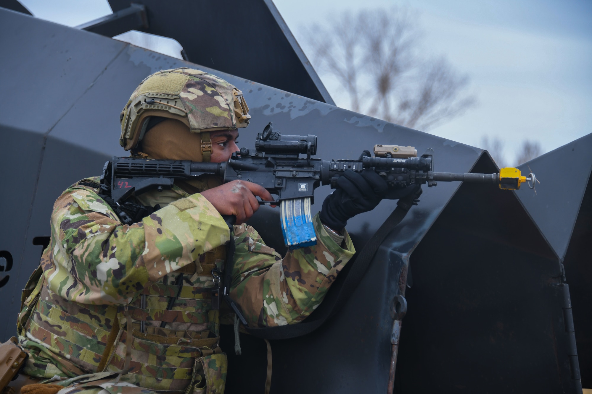 Military member looks down the sight of his rifle.