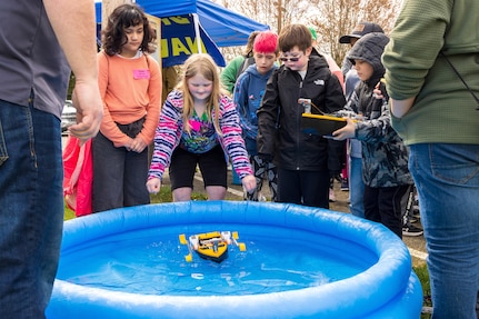 Fourth grader Cora Morgan floats a remote controlled boat with her classmates, April 16, 2024, during the annual Kitsap Water Festival at the Kitsap County Fairgrounds in Bremerton, Washington. (U.S Navy photo by Wendy Hallmark)