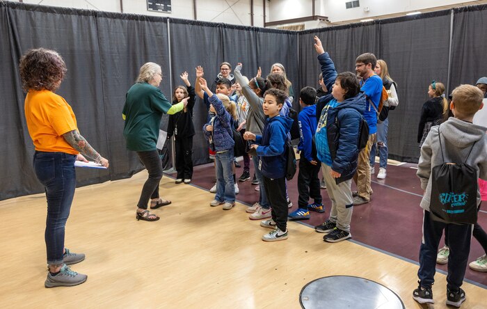 Volunteers from the Exceptional Family Members Program at Naval Base Kitsap help students during a hearing sensory activity at the Kitsap County Fairgrounds in Bremerton, Washington April 16, 2024, in support of the 2024 Kitsap Water Festival. (U.S Navy Photo by Wendy Hallmark)