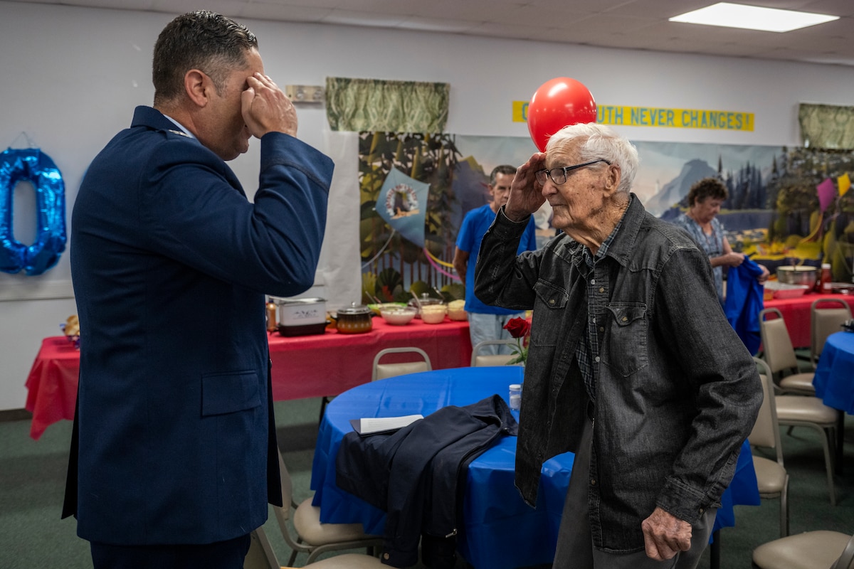 James Herring, a retired U.S. Air Force chief master sergeant and WWII veteran, salutes U.S. Air Force Col. Bobby Buckner, 23rd Maintenance Group commander