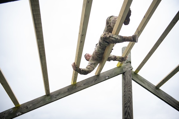 Spc. Thomas Gist, a Tulsa, Oklahoma resident and member of the 2120th Engineer Support Company, 120th Engineer Battalion, 90th Troop Command, climbs through the weaver during the obstacle course challenge at the Oklahoma Army National Guard Best Warrior Competition at Camp Gruber Training Center, April 26, 2024. (Oklahoma National Guard photo by Sgt. Haden Tolbert)