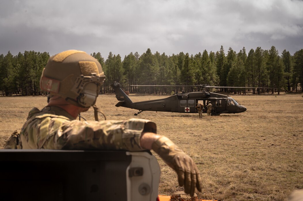 A U.S. Air Force Airman assigned to the 56th Civil Engineer Squadron Explosive Ordnance Disposal flight observes an Arizona National Guard UH-60 Black Hawk, assigned to the ANG Silverbell Army Heliport in Marana, Arizona, during Operation Pegasus at Camp Navajo, Arizona, April 21st-26th, 2024.