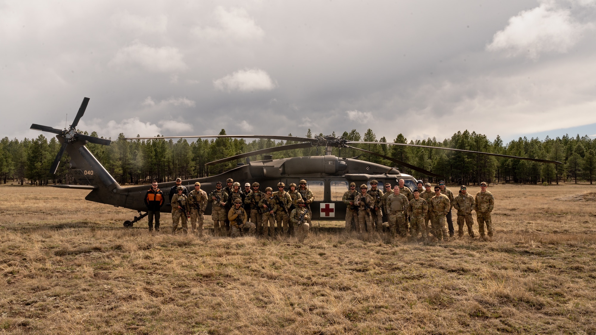 U.S. Air Force Airmen assigned to the 56th Civil Engineer Squadron Explosive Ordnance Disposal flight, and U.S. Army Soldiers assigned to the Arizona National Guard Silverbell Army Heliport in Marana, Arizona, pose for a group photo in front of an ANG medical evacuation UH-60 Black Hawk, during Operation Pegasus at Camp Navajo, Arizona, April 21-26, 2024.