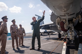 U.S. Navy Capt. Brian Schrum gives a tour of the ship’s flight deck and aircraft to Royal Thai Navy officers.