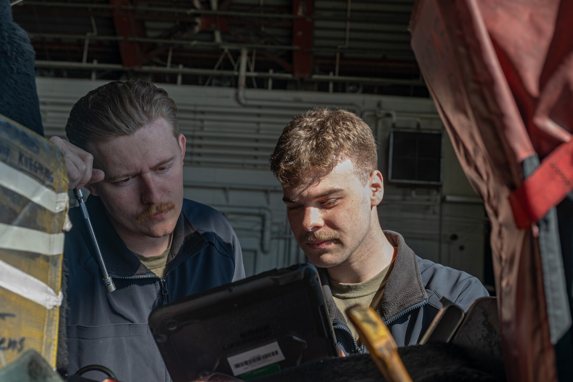 Service members read a technical order.