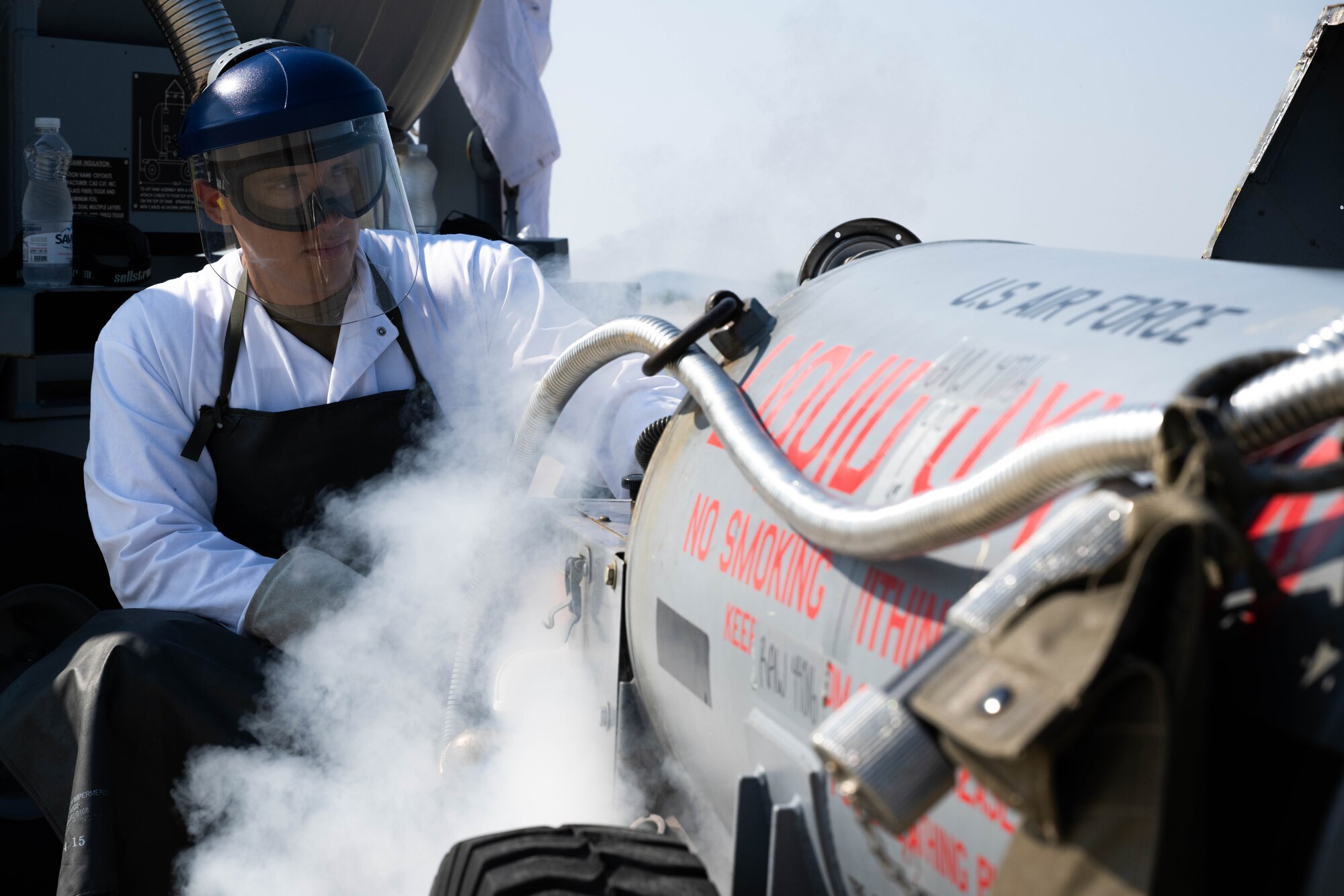 Fuels facilities specialist, fills a cart of liquid oxygen.
