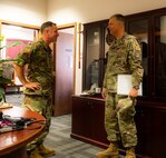 U.S. Air Force Col. Darren Duncan, U.S. Strategic Command command chaplain (right), is greeted by U.S. Air Force Col. James Schlabach, 5th Bomb Wing commander, at Minot Air Force Base, North Dakota, July 31, 2024. The two leaders discussed ongoing initiatives to support the spiritual resilience of Airmen stationed at Minot AFB, highlighting the importance of comprehensive wellness programs for mission readiness and overall well-being. (U.S. Air Force photo by Airman 1st Class Luis Gomez)