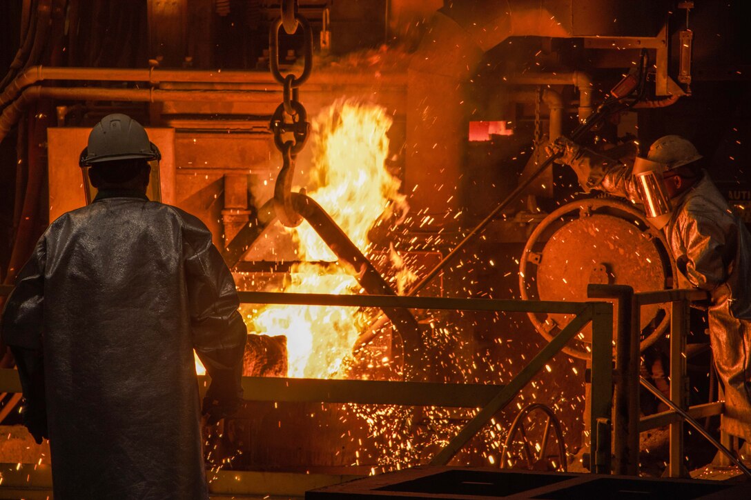 Sparks fly as personnel wearing helmets and face coverings work on a fire in mechanical room.