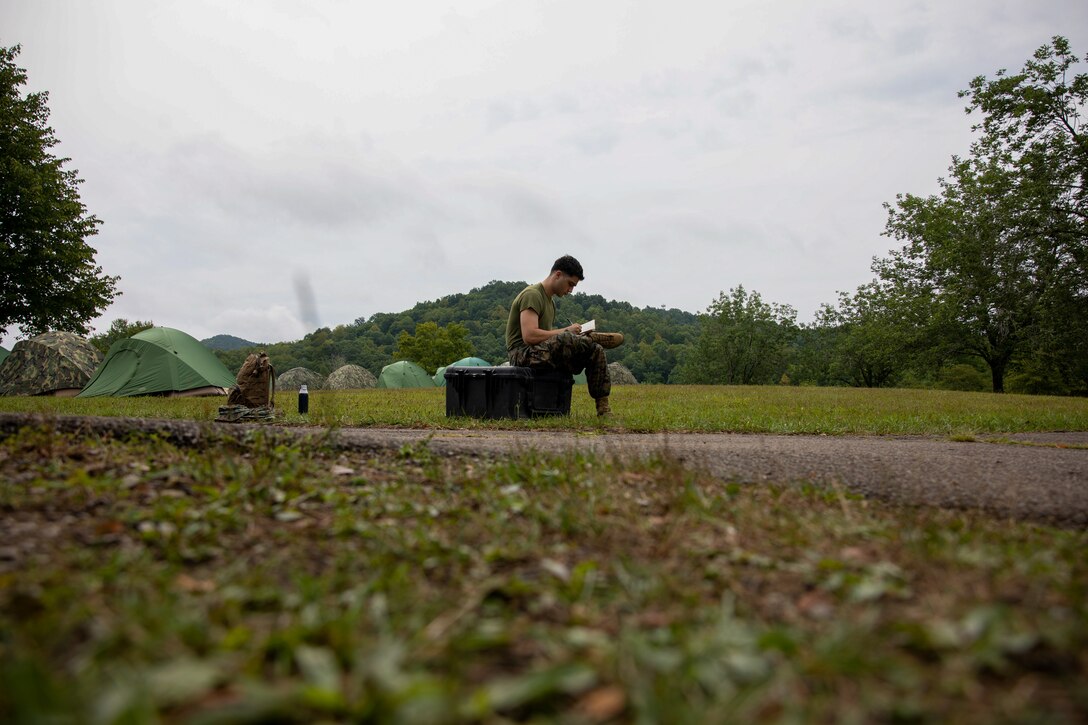 U.S. Marine Corps Lance Cpl. Tamazi Neparidze, a native of New York and a satellite transmissions systems operator, 6th Communications Battalion, Force Headquarters Group, Marine Forces Reserve, writes in his journal during Innovative Readiness Training, Stonewall State Park, West Virginia, July 24, 2024. IRT provides a training opportunity for Marines by engaging with the community, conducting civil projects and increasing military occupational specialty proficiency. (U.S. Marine Corps photo by Lance Cpl. Kanoa Thomas)