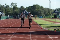 U.S. Army Staff Sgt. Adam Proctor, left, and veteran Patrick Dayton run together at the track event during the 2024 Department of Defense Warrior Games