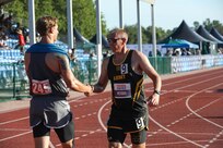 U.S. Army Sgt. 1st Class Jeffrey Peters shakes hands with a Team SOCOM athlete after a race at the track event during the 2024 Department of Defense Warrior Games