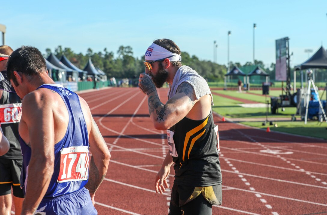 U.S. Army veteran Patrick Dayton takes a drink of water after his race at the track event during the 2024 Department of Defense Warrior Games