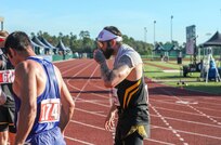 U.S. Army veteran Patrick Dayton takes a drink of water after his race at the track event during the 2024 Department of Defense Warrior Games