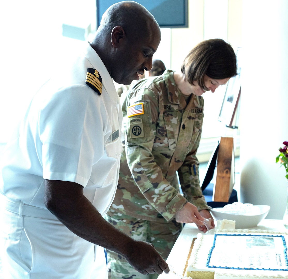 U.S. Navy Capt. (Dr.) Carlos D. Williams and U.S. Army Lt. Col. (Dr.) Shannon C. Ford share in a cake cutting during a ceremony at which Williams relinquished the directorship of the National Intrepid Center of Excellence, and Ford became the new director of center noted for its care of service members who exhibit the many symptoms of traumatic brain injury (TBI), post-traumatic stress (PTS), located at Walter Reed National Military Medical Center on July 30, 2024.