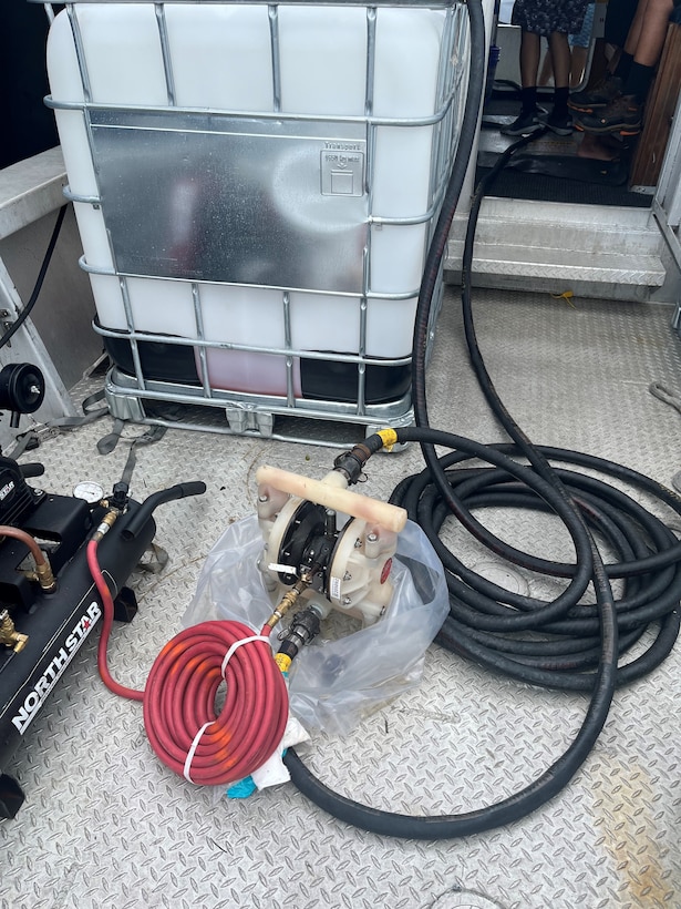 Photo showing transfer hose and a tote receiving the fuel from the grounded sailing vessel catamaran Obsession being recovered by Resolve Marine and Clean Harbors personnel July 31, 2024, just off Flamenco Beach in Culebra, Puerto Rico.  The Coast Guard established and Incident Command with local and federal interagency partners, July 26, 2024, to oversee the removal of an estimated 800 to 1,500 gallons of diesel from the vessel as well as the engine oil and any potential hazardous materials onboard. (Courtesy photo)