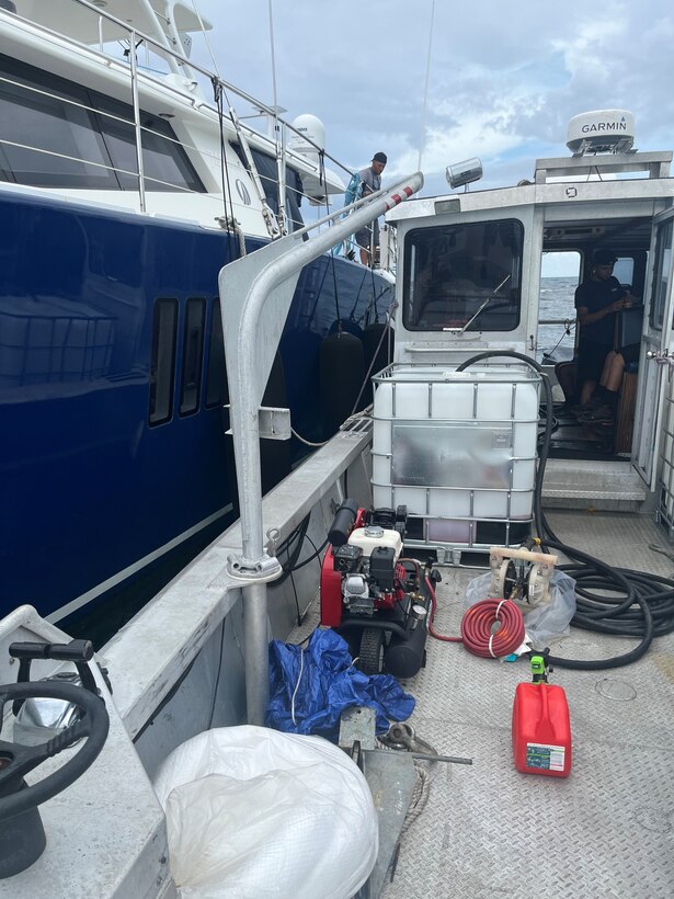 Photo showing vessel and tote receiving the fuel from the grounded sailing vessel catamaran Obsession being recovered by Resolve Marine and Clean Harbors personnel July 31, 2024, just off Flamenco Beach in Culebra, Puerto Rico.  The Coast Guard established and Incident Command with local and federal interagency partners, July 26, 2024, to oversee the removal of an estimated 800 to 1,500 gallons of diesel from the vessel as well as the engine oil and any potential hazardous materials onboard. (Courtesy photo)