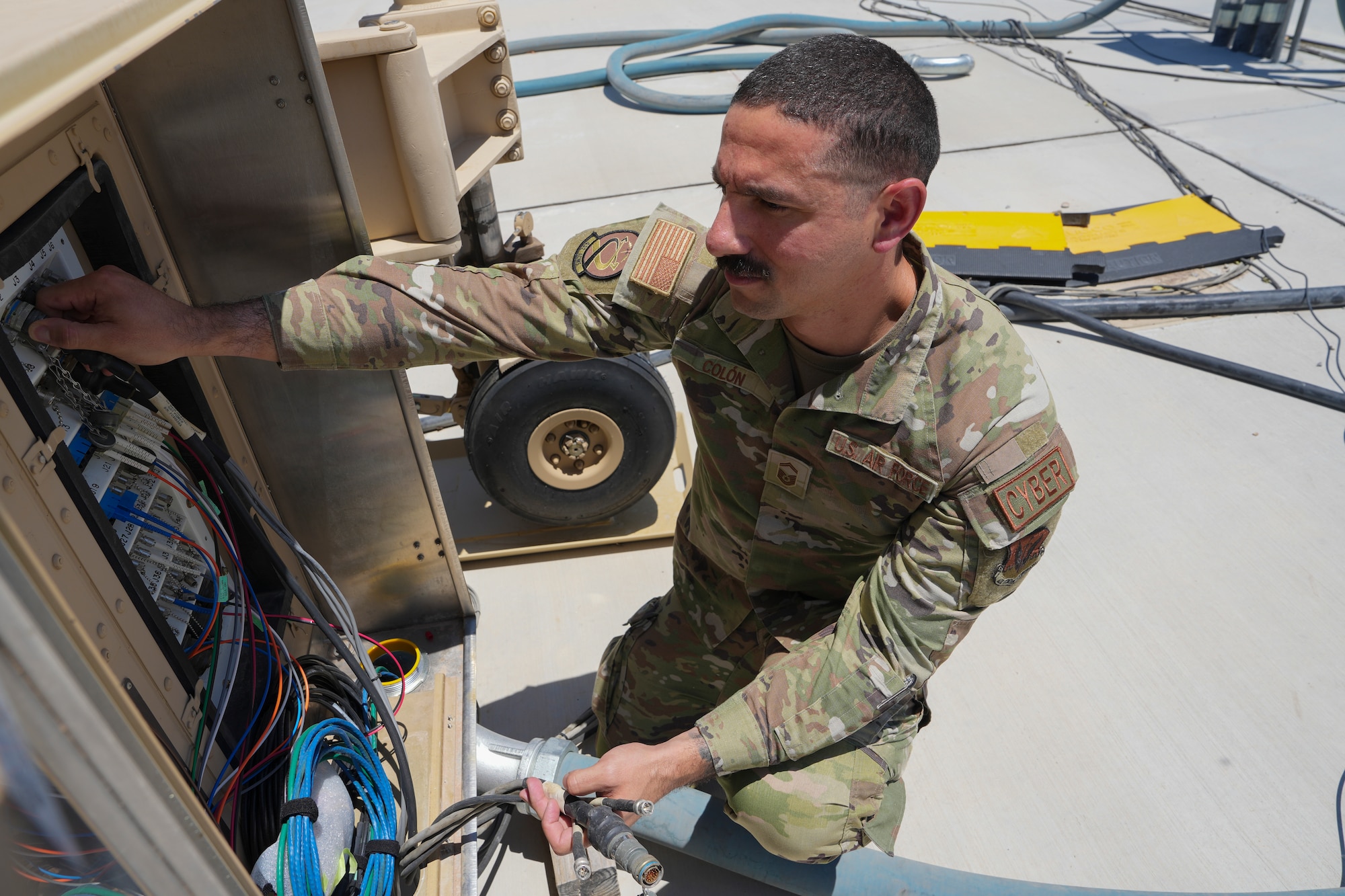 An airman works on a ground control station.