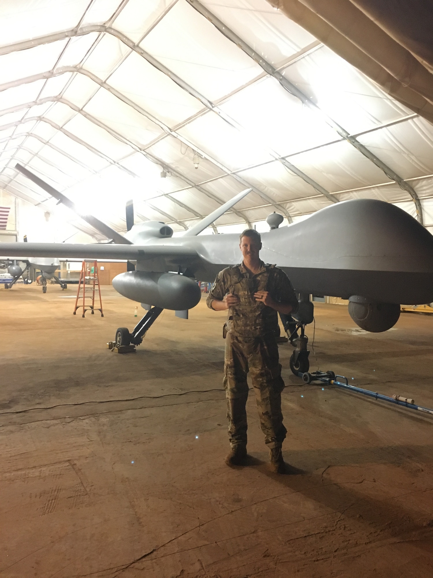 An Airman stands in front of an RPA