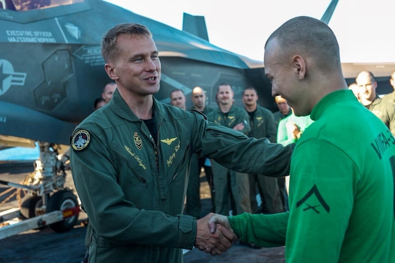 Lt. Col. Jeffrey Davis, left, commanding officer of Marine Fighter Attack Squadron 314, awards the commanding officer coin for excellence to Lance Cpl. Nicholas Miller, an F-35C airframes mechanic, aboard the flight deck of the Nimitz-class aircraft carrier USS Abraham Lincoln (CVN 72), July 20, 2024, while underway in the Pacific Ocean. VMFA 314, assigned to Carrier Air Wing 9 aboard the Lincoln, is underway conducting routine operations in the U.S. 7th Fleet area of operations. (U.S. Marine Corps courtesy photo)