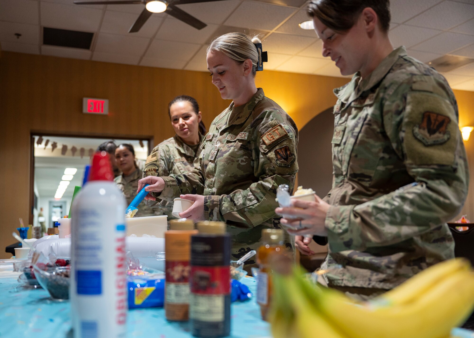 U.S. Airmen get ice cream during an ice cream social at the community center at Davis-Monthan Air Force Base, Ariz., July 31, 2024. Airmen from around base were invited to participate in the event and were served ice cream before learning about the resources that True North have available. (U.S. Air Force photo by Airman 1st Class William Finn V)