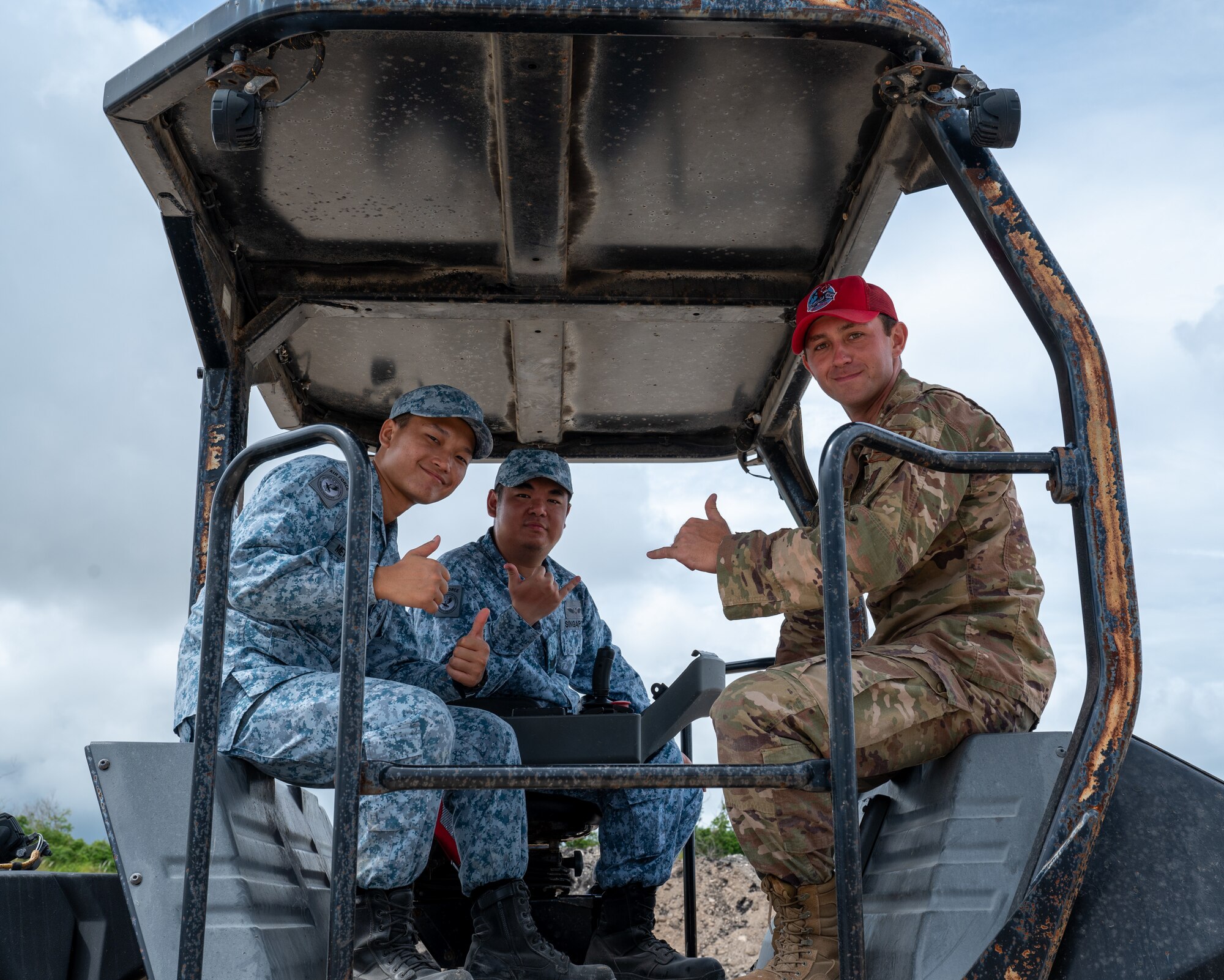 A U.S. Air Force 554th Rapid Rapid Engineer Deployable Heavy Operational Repair Squadron Engineer cadre and members from the Republic of Singapore Air Force pose for a photo on top of a heavy machinery at the Pacific Regional Training Center-Andersen, Guam, July 25, 2024. Silver Flag allows U.S. partners and allies to familiarize themselves with the techniques and equipment that the U.S. Air Force utilizes to ensure airfields can support, launch and recover aircraft. (U.S. Air Force Photo by Airman 1st Class Manasseh Demissie)