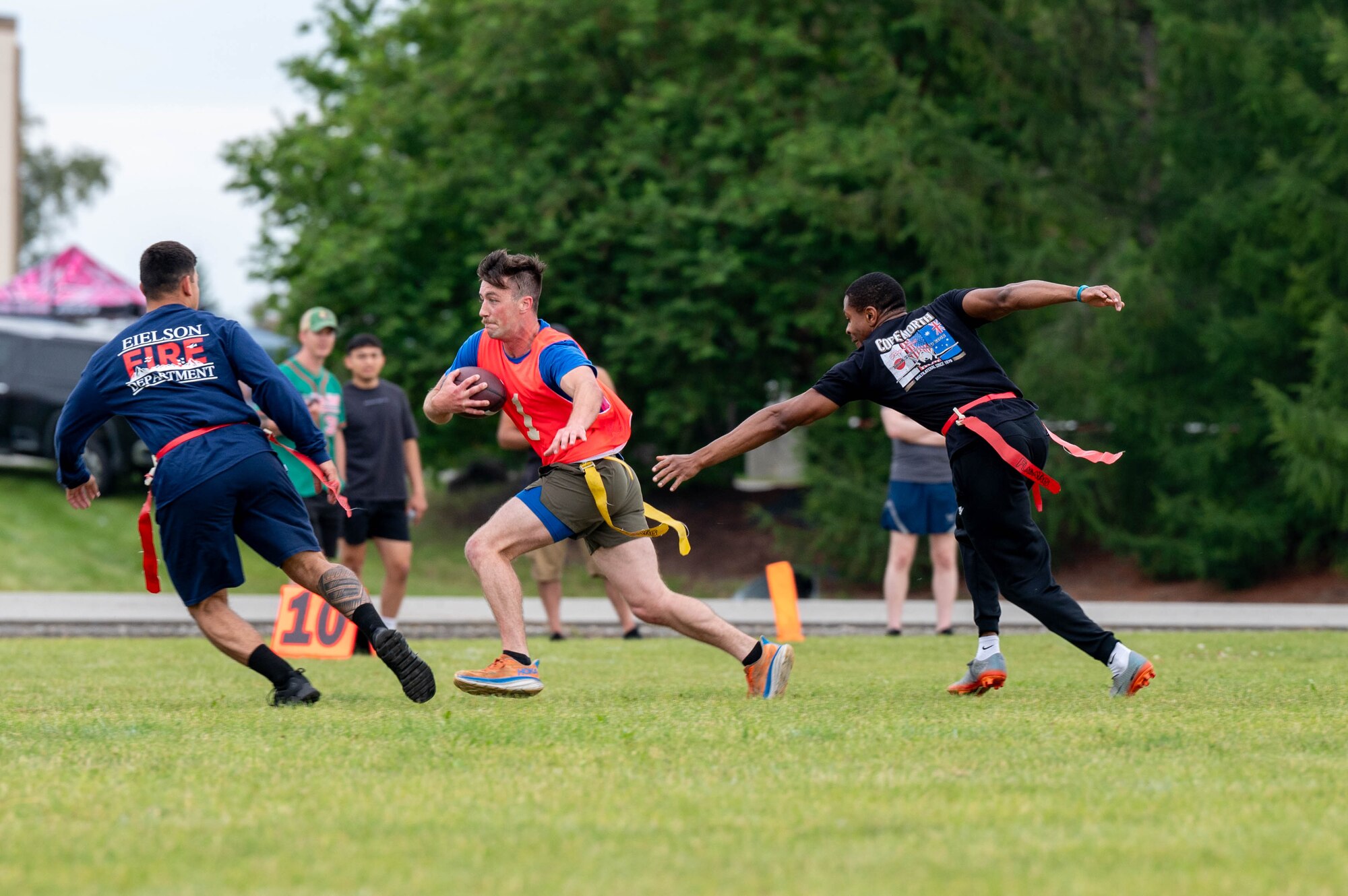 U.S. Air Force 2nd Lt. Colten Riley, 354th Comptroller Squadron financial services officer in charge, runs between defenders during a flag football competition