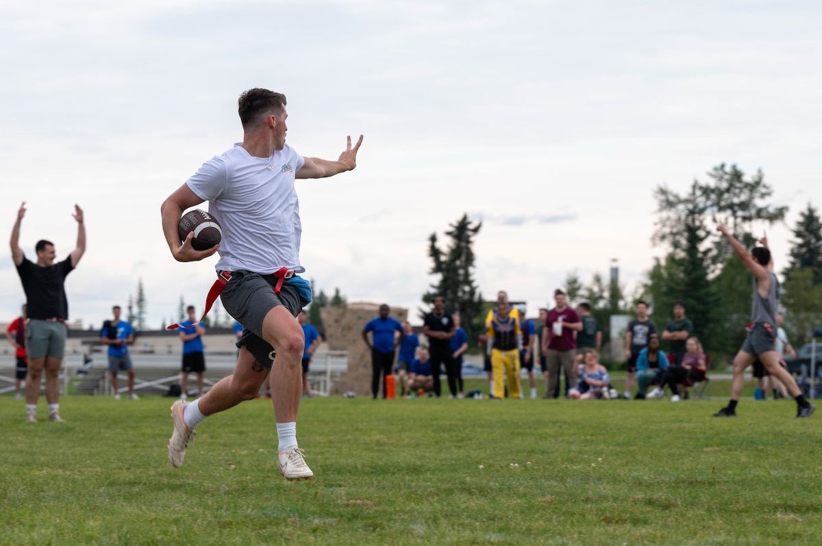 U.S. Air Force Airman 1st Class Mason Urich, 354th Munitions Squadron stockpile management technician, runs for a touchdown during a flag football competition