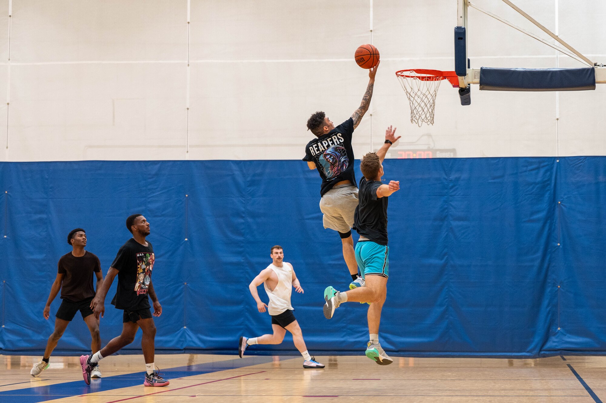 U.S. Air Force Senior Airman Jayden Allende, 18th Fighter Generation Squadron weapons load crew member, completes a layup during a basketball competition