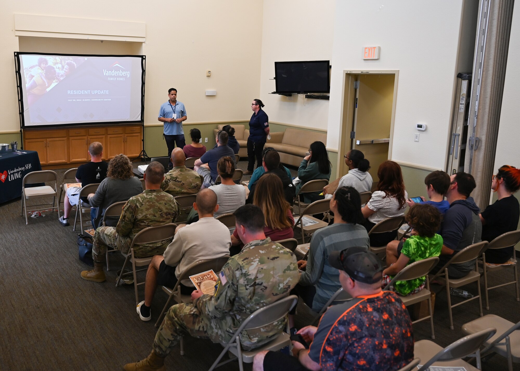 People listen to a presentation about base housing.