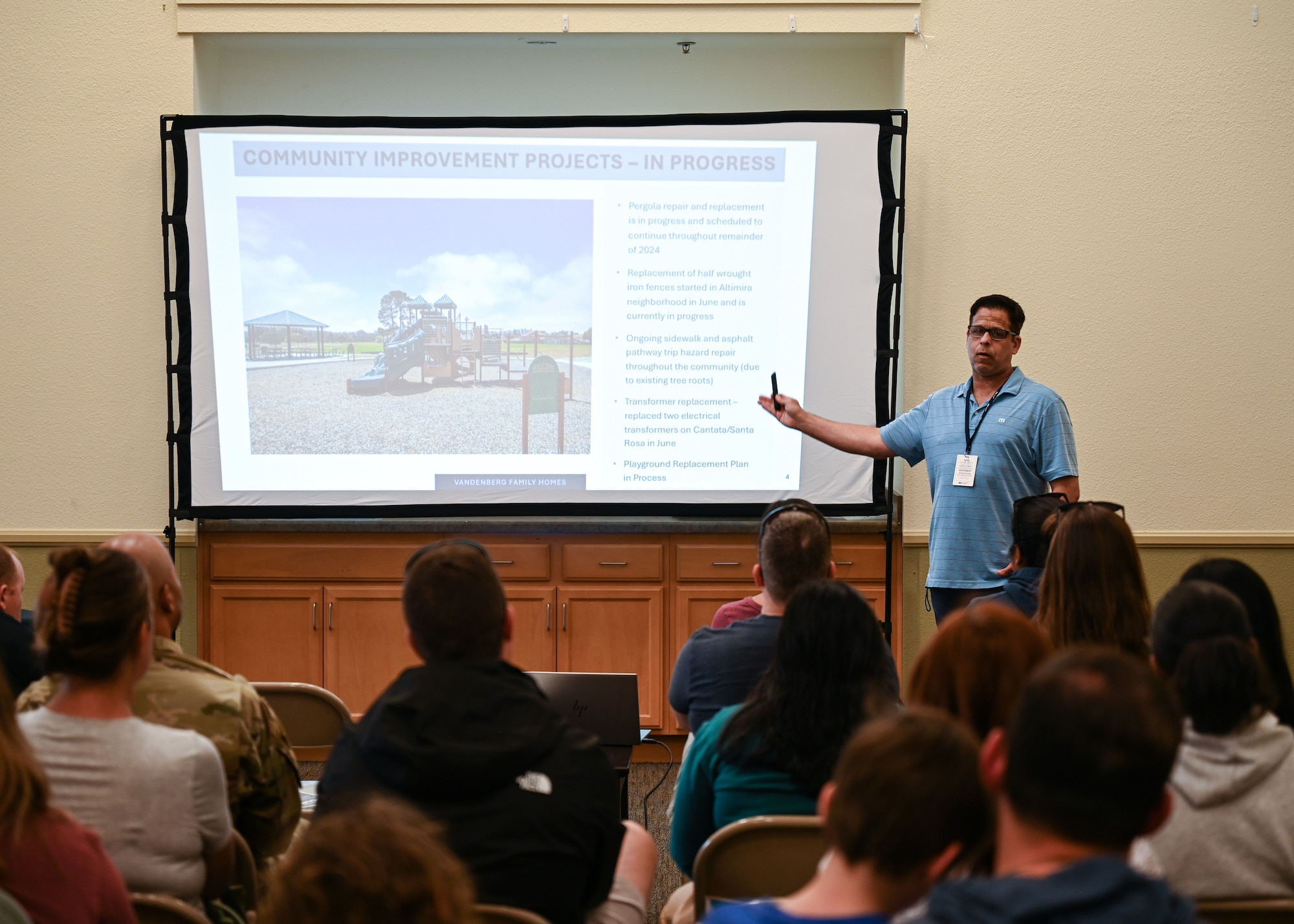 People listen to a presentation about base housing.