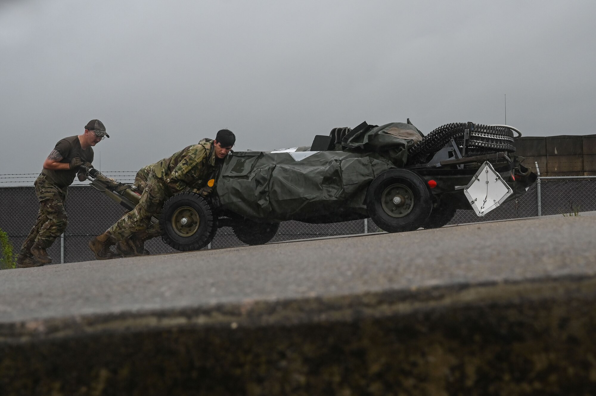 Senior Airman Johnathon Clark, left, 8th Logistics Readiness Squadron packing and crating supervisor, and Senior Airman Ryan Cimino, 8th Logistics Readiness Squadron inbound cargo technician, push a bomb loader up a ramp during a cargo deployment function.