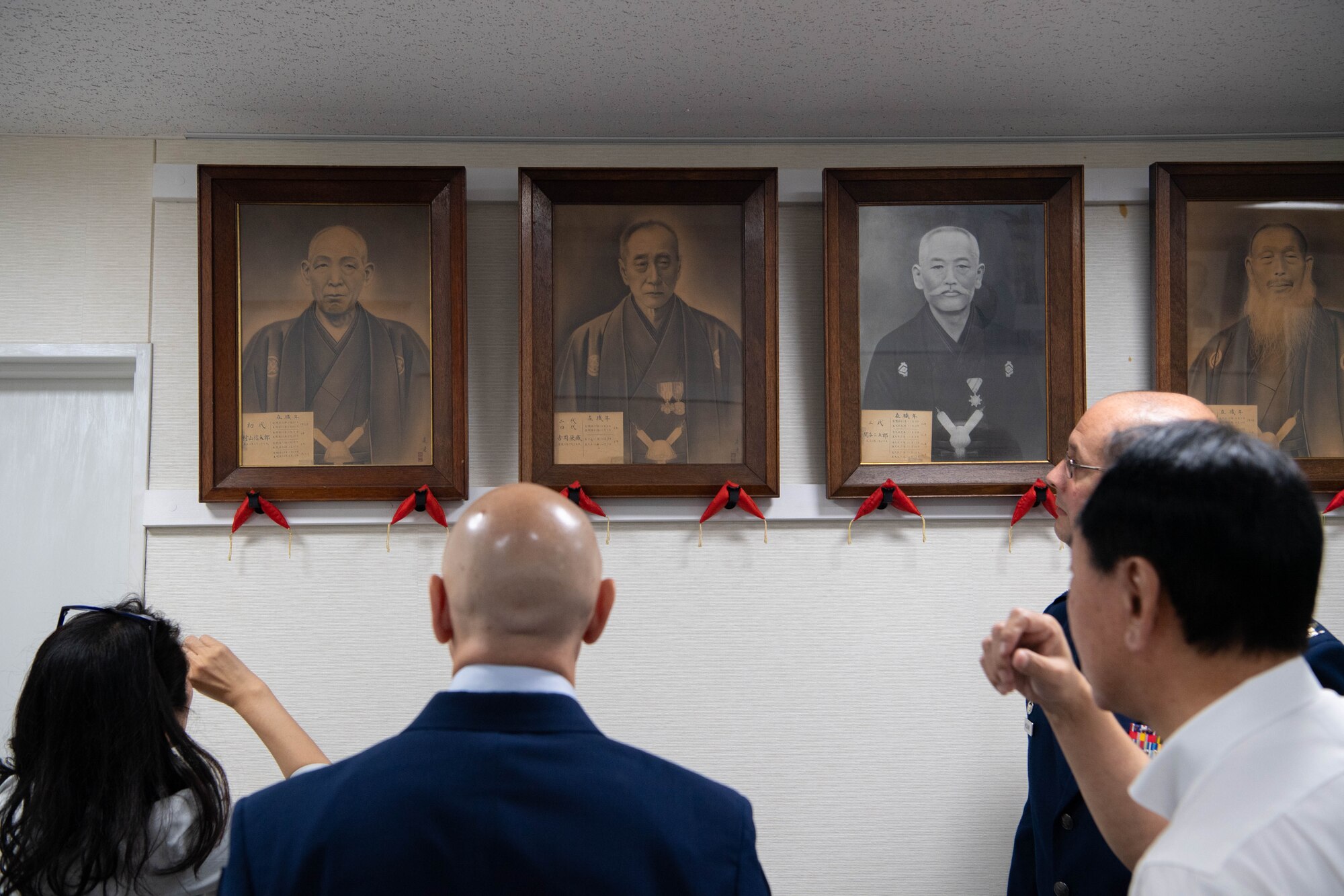 A group of people view portraits.