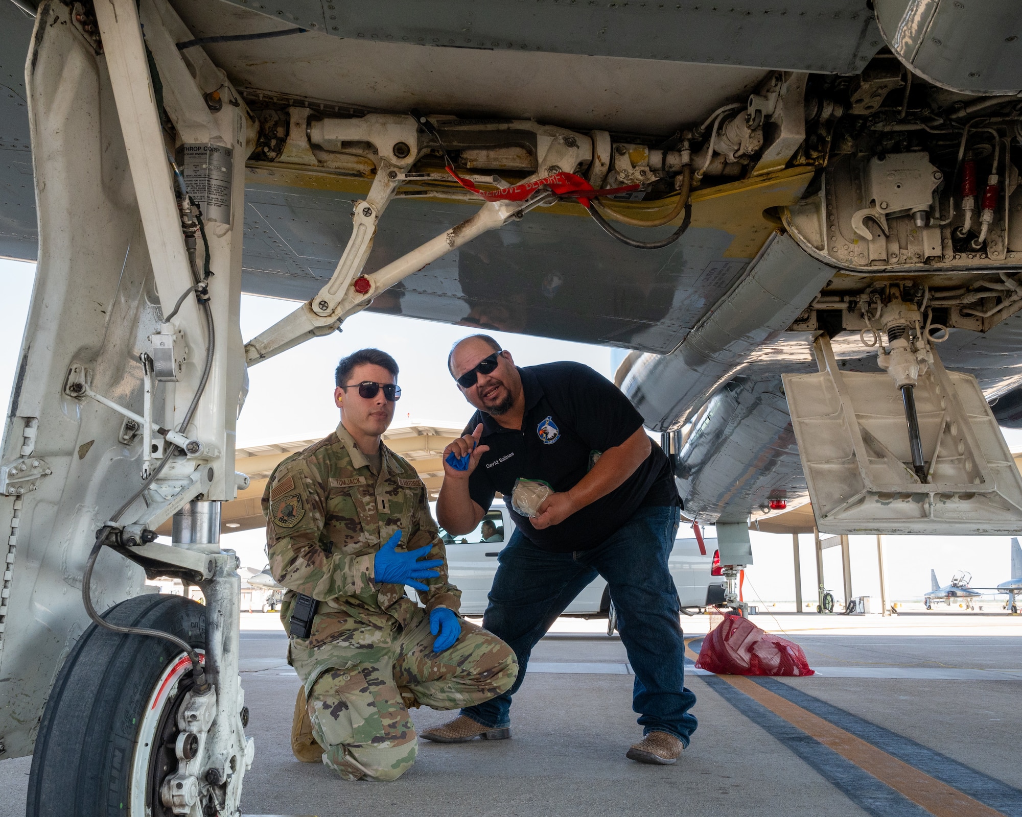 David Salinas, right, 47th Maintenance Division safety office intern, and U.S. Air Force 1st Lt. Joshua Tomjack, left, 47th Flying Training Wing safety office, inspect the undercarriage of a T-38C Talon wheel during an inspection at Laughlin Air Force Base, Texas, July 2, 2024. The Safety Office inspects areas all over the base, including the flightline, maintenance areas, and offices, to ensure compliance with safety protocols. (U.S. Air Force photo by Staff Sgt. Nicholas Larsen)