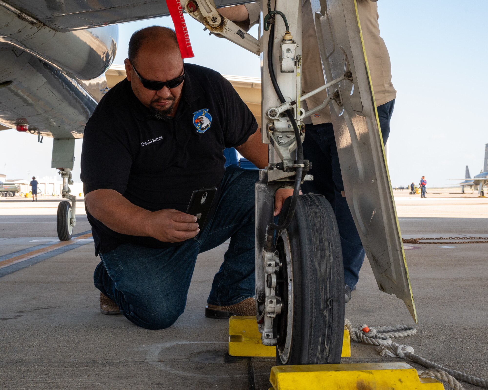 David Salinas, 47th Maintenance Division safety office intern, takes a photo of a T-38C Talon wheel during an inspection at Laughlin Air Force Base, Texas, July 2, 2024. The Safety Office inspects areas all over the base, including the flightline, maintenance areas, and offices, to ensure compliance with safety protocols. (U.S. Air Force photo by Staff Sgt. Nicholas Larsen)