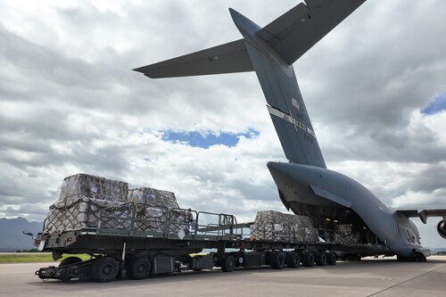 Airmen unloading cargo from an aircraft