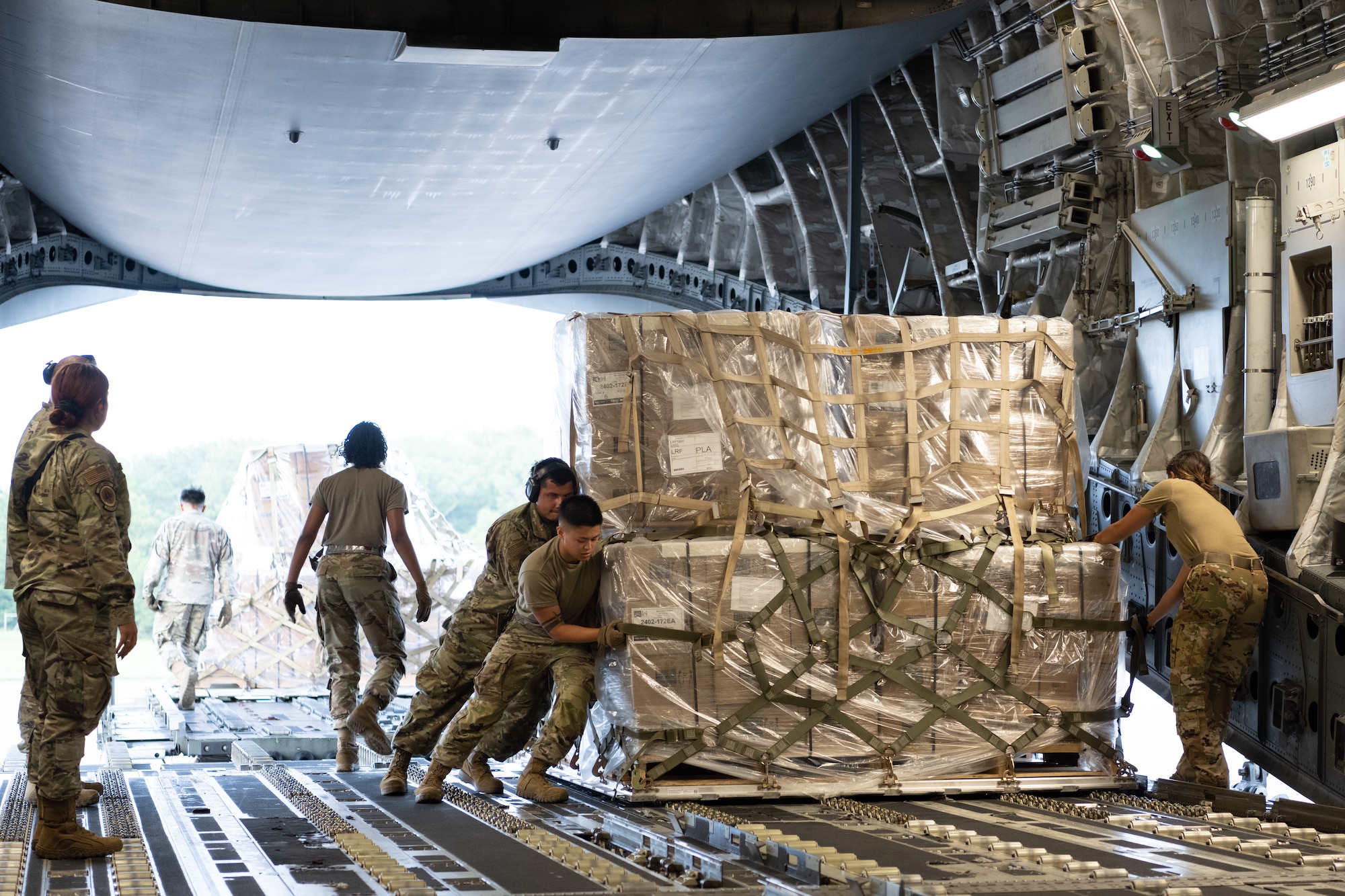 Airmen push cargo in the aircraft