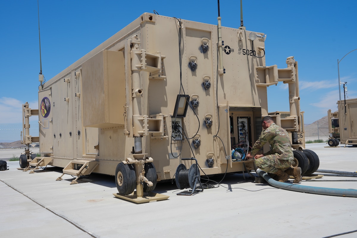 An airman works on a ground control station.