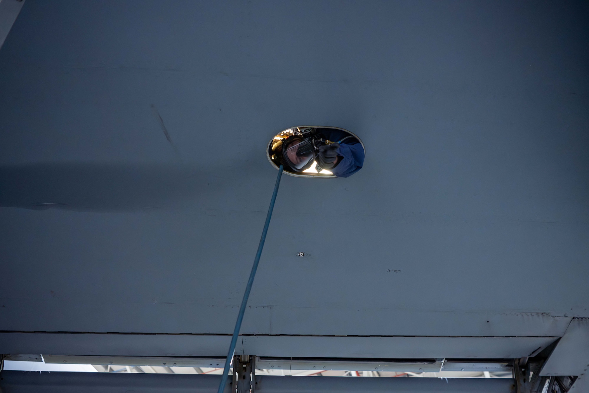 An aircraft fuels system specialist assigned to the 379th Expeditionary Maintenance Squadron poses for a photo from inside the fuel tank of a KC-135 Stratotanker at an undisclosed location within the U.S. Central Command area of responsibility, July 26, 2024.